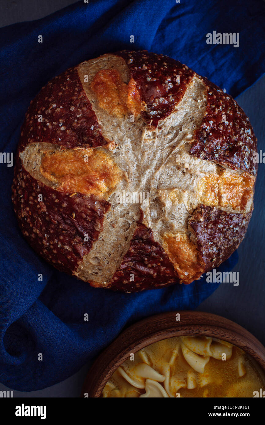 Cheddar Brezel Roggenbrot auf einer Indigo Bettwäsche Serviette und schwarzen Hintergrund Stockfoto