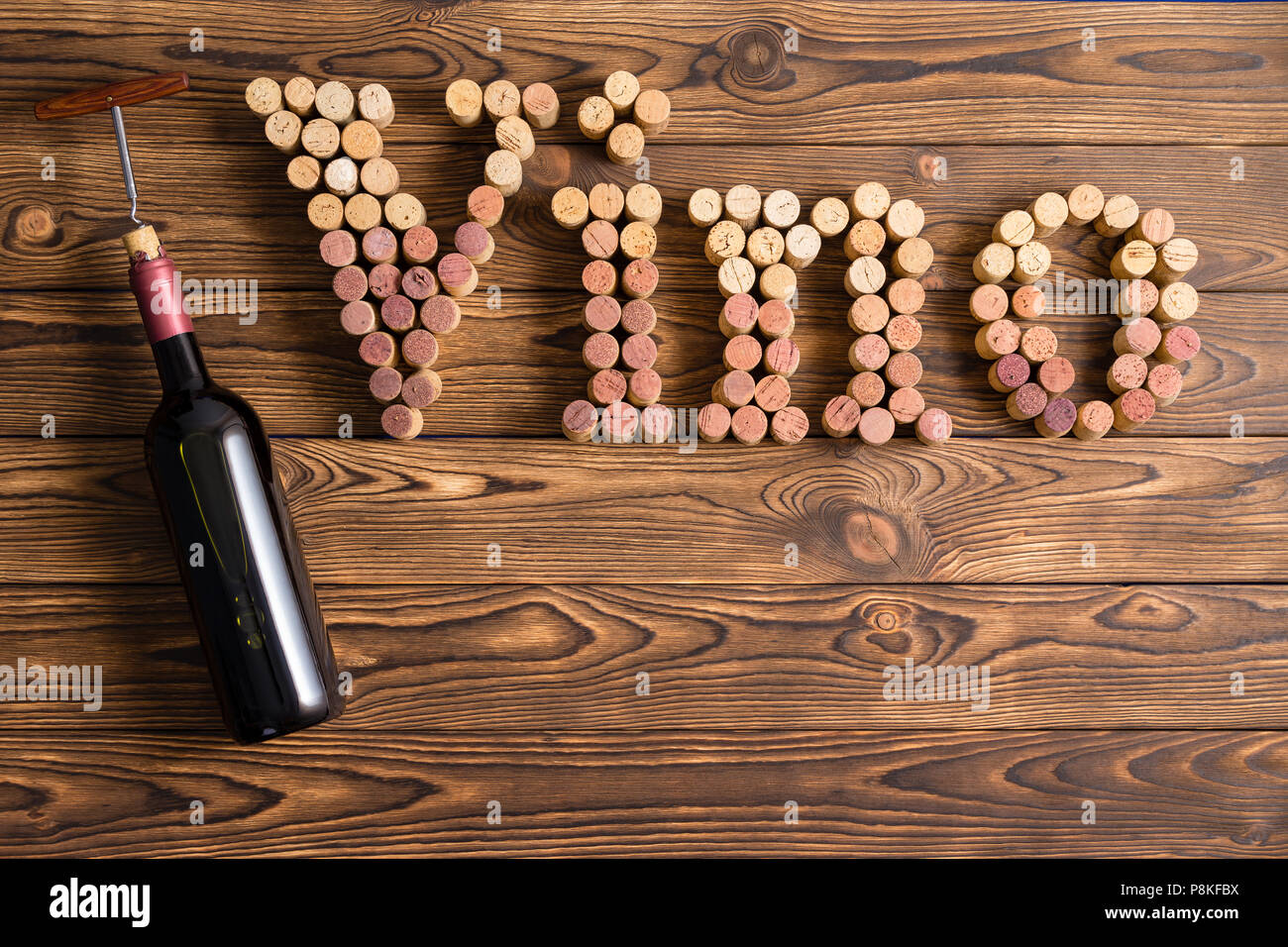 Vino Schriftzug von Korken mit Flasche gegen Holz- Hintergrund Stockfoto