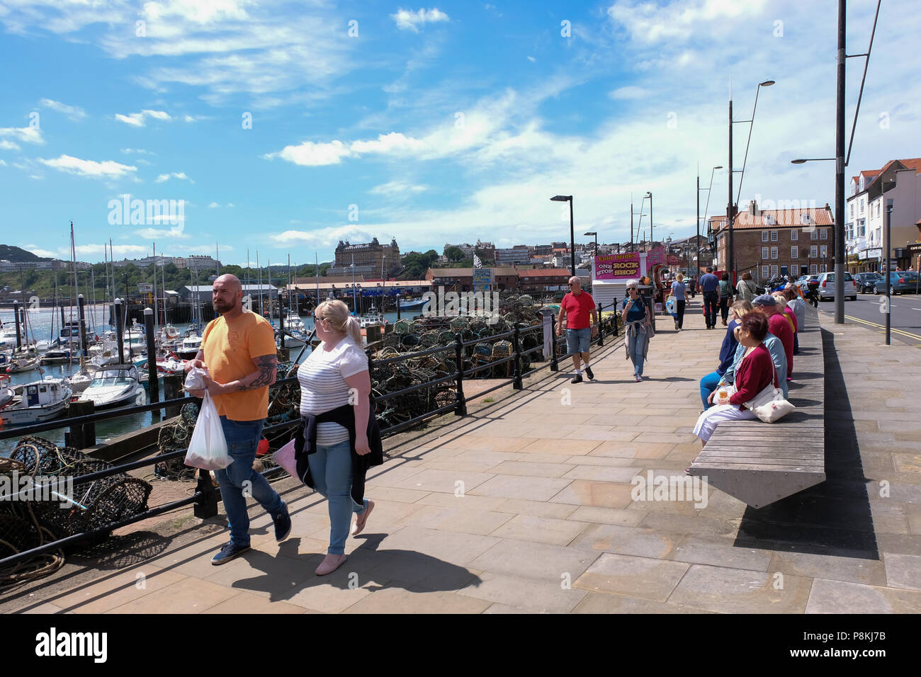 Urlauber und Familien wandern die Promenade in der North Yorkshire Holiday Resort Scarborough, Großbritannien Stockfoto