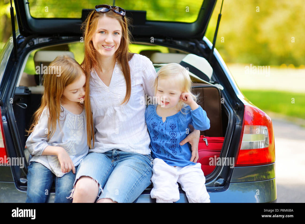 Zwei Entzückende kleine Schwestern und ihrer Mutter in einem Auto sitzen nur vor dem Verlassen für ein Auto Vermietungen Stockfoto
