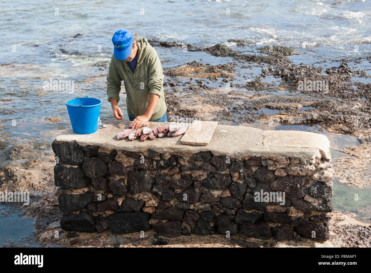 Mann Reinigung/ausnehmen Fische auf La Graciosa Island in der Nähe von Lanzarote auf den Kanarischen Inseln, Spanien Stockfoto