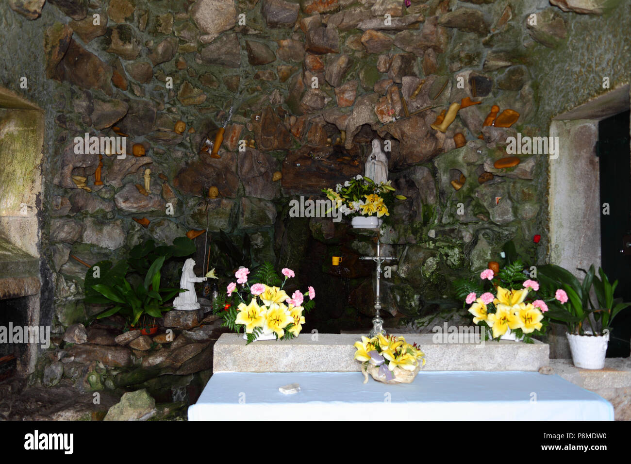 Jungfrau von Lourdes Statue, Feder und Wachs Körperteile in Grotte auf dem Monte do Calvario, Vila Praia de Ancora, Provinz Minho, Nordportugal Stockfoto