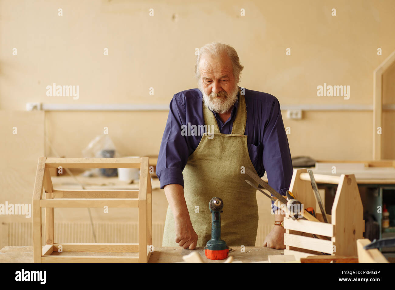 Nachdenklich alte Master ruht sich nach der grundlegenden von Dollhouse. eine Pause bei der Arbeit Stockfoto