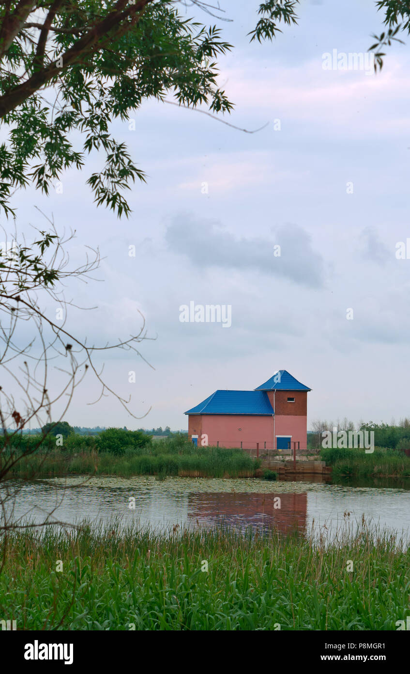 Rosa Haus mit blauem Dach, einsamen Haus am See, Juni 11, 2018, der Region Kaliningrad, Russland Stockfoto
