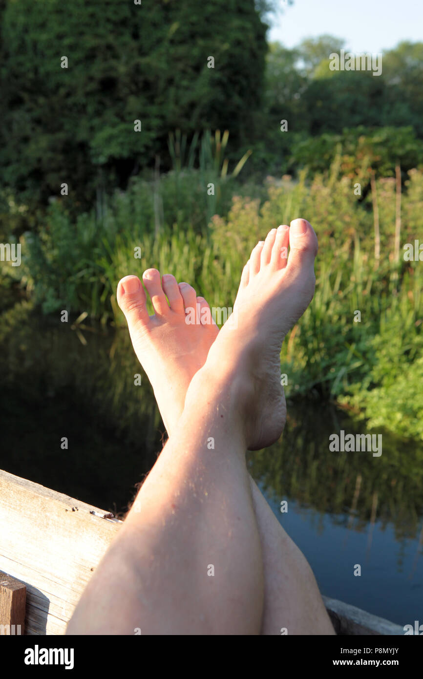 Die Füße hoch und entspannen durch den Fluss an einem spätsommerabend in Südengland. 2018. Stockfoto