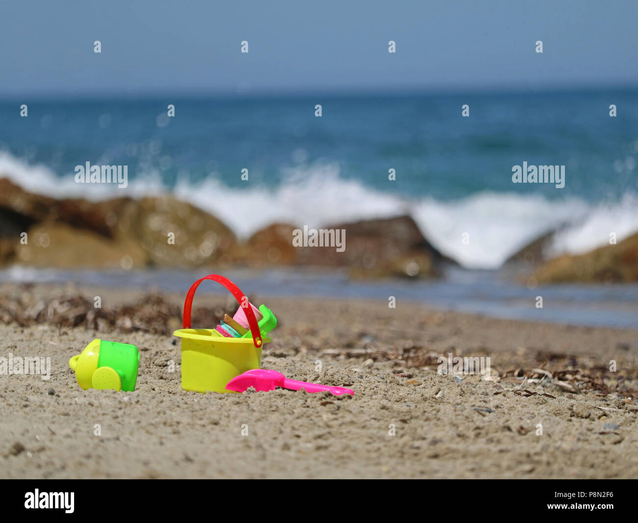 Buntes Spielzeug, Eimer und Schaufel, in Sand mit Meerblick Stockfoto