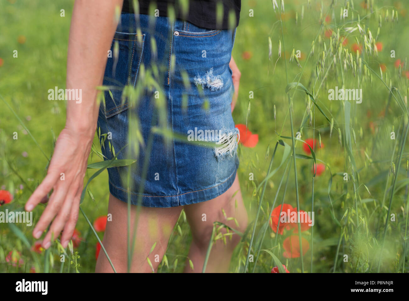 Frau beim Spaziergang in einem mohnfeld unter der Sommersonne