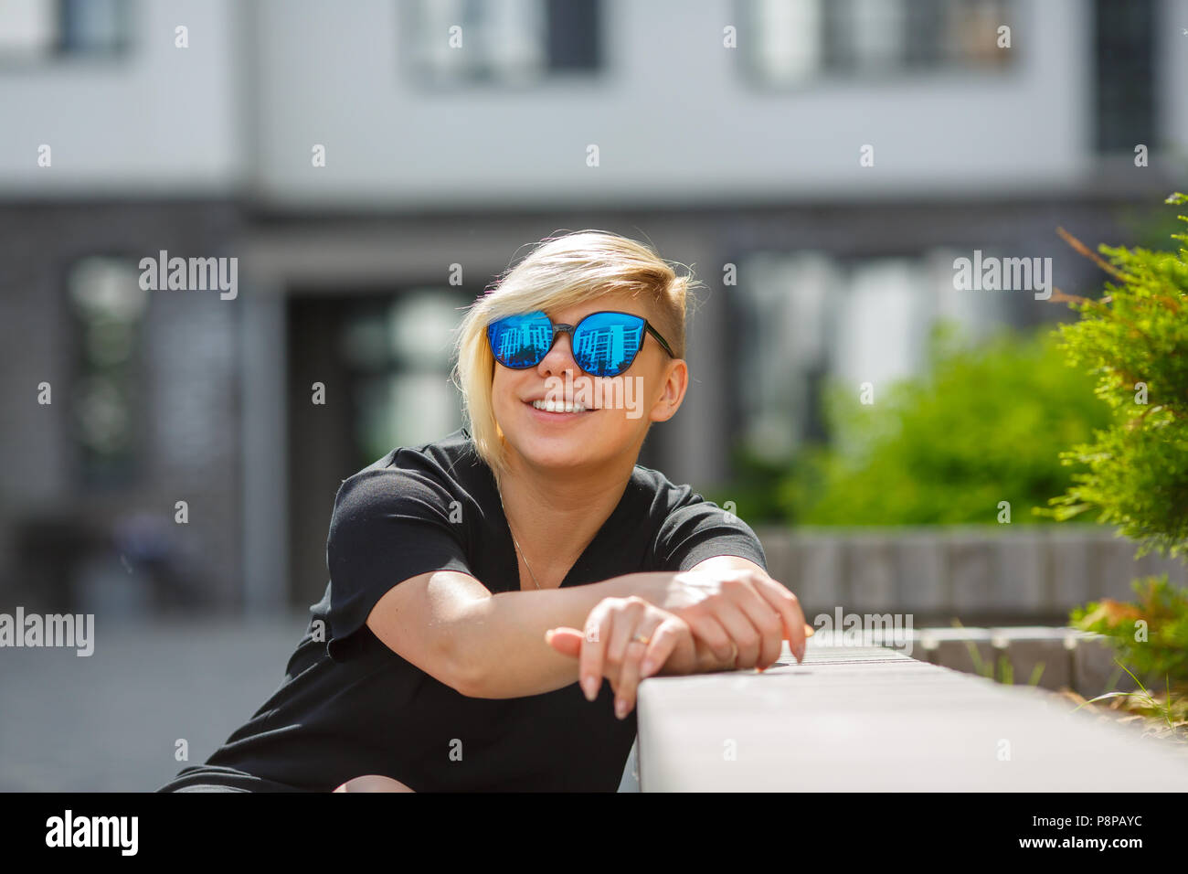 Das Mädchen plus Größe in Sonnenbrille, Lächeln, Freude, an einem sonnigen Tag auf der Straße fröhlich, ein Haarschnitt ist assynchronous, kreative, ungewöhnliche. Kauf, Cho Stockfoto