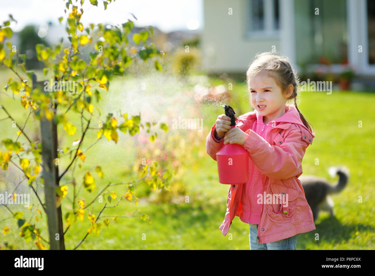 Die entzückende kleine Mami helper Bewässerung von Pflanzen im Garten an einem wunderschönen Herbsttag Stockfoto