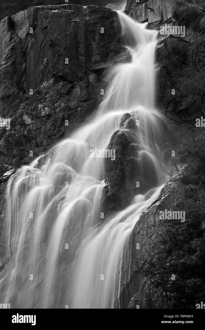 Ein Wasserfall fällt von den steilen Klippen auf der rund um die ANNAPURNA TREK - NUPRI REGION NEPALS Stockfoto