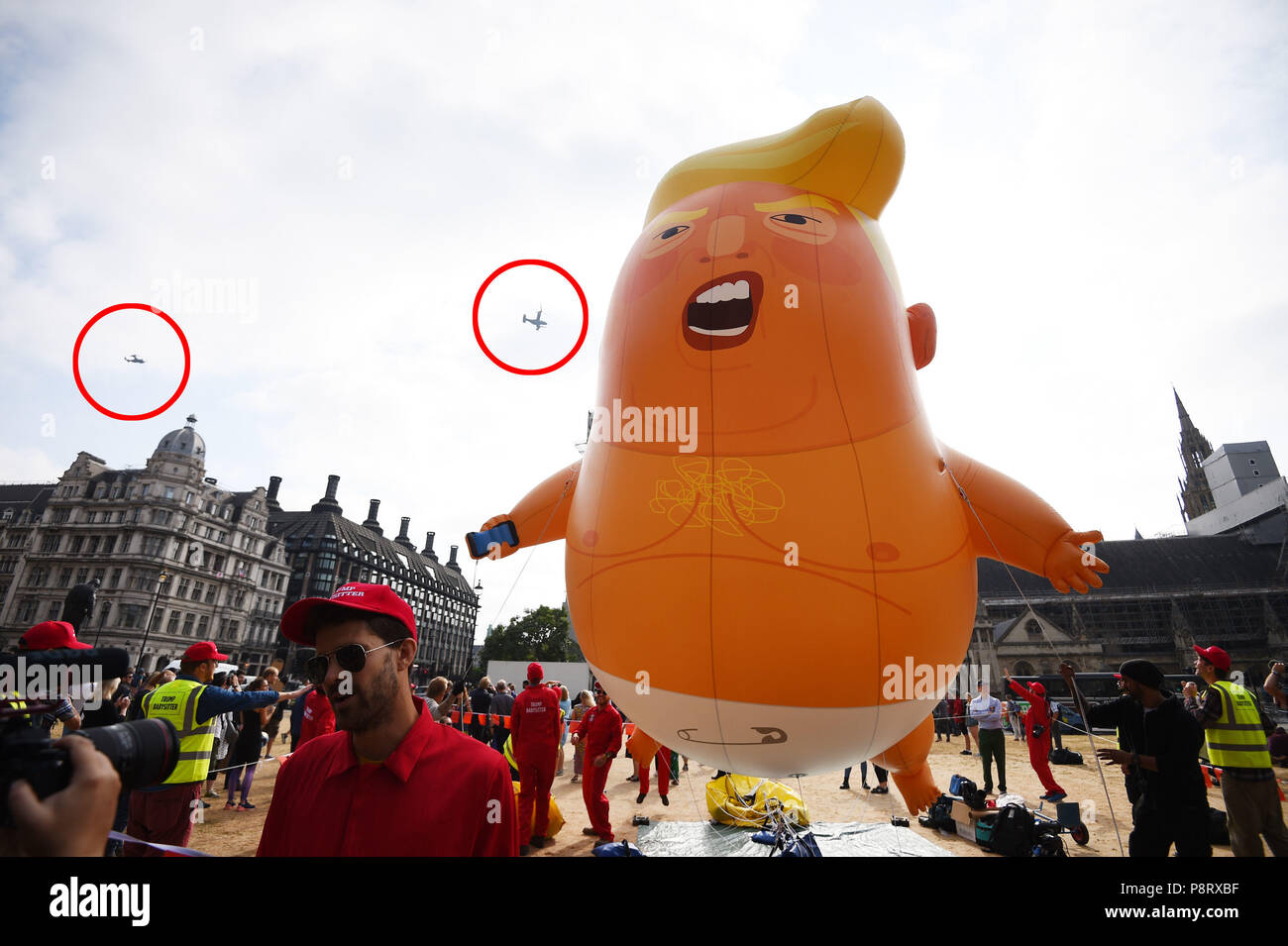 US Marine Hubschrauber (Beringt), die durch die Präsidentschaftswahlen entourage verwendet werden, pass Ballon die "Baby Trumpf", wie es nach der im Londoner Parlament Platz Inflation steigt, als Teil der Proteste gegen den Besuch von US-Präsident Donald Trump nach Großbritannien. Stockfoto