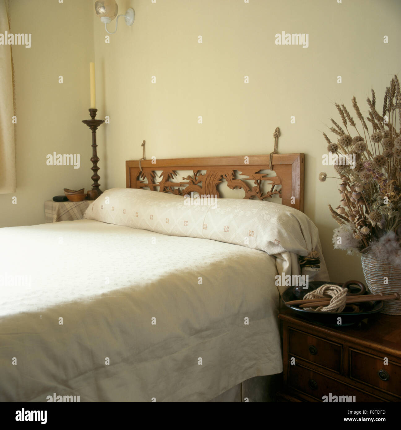 Geschnitzten hölzernen Kopfteil auf neutral Schlafzimmer mit Creme  Bettwäsche-Bett Stockfotografie - Alamy