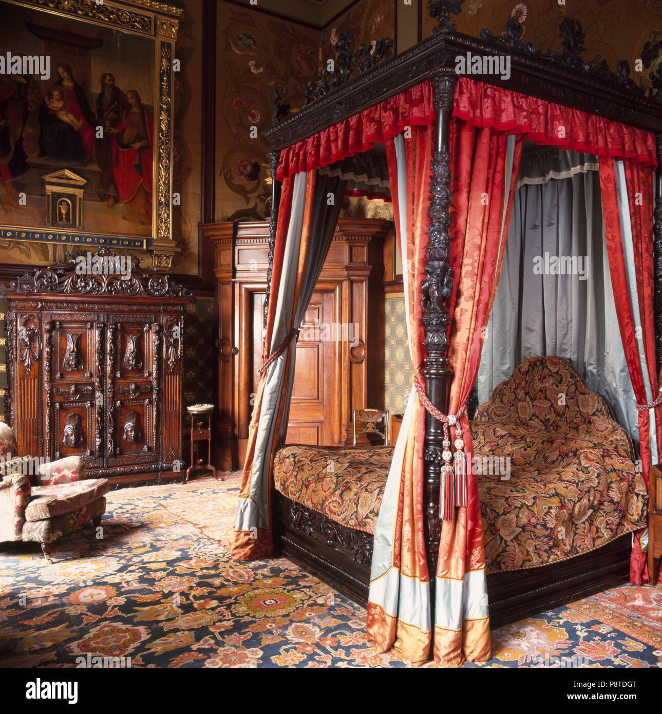 Himmelbett mit opulenten Vorhänge und Bettbezüge in Landhaus Schlafzimmer  mit gemusterten orientalischen Teppich Stockfotografie - Alamy