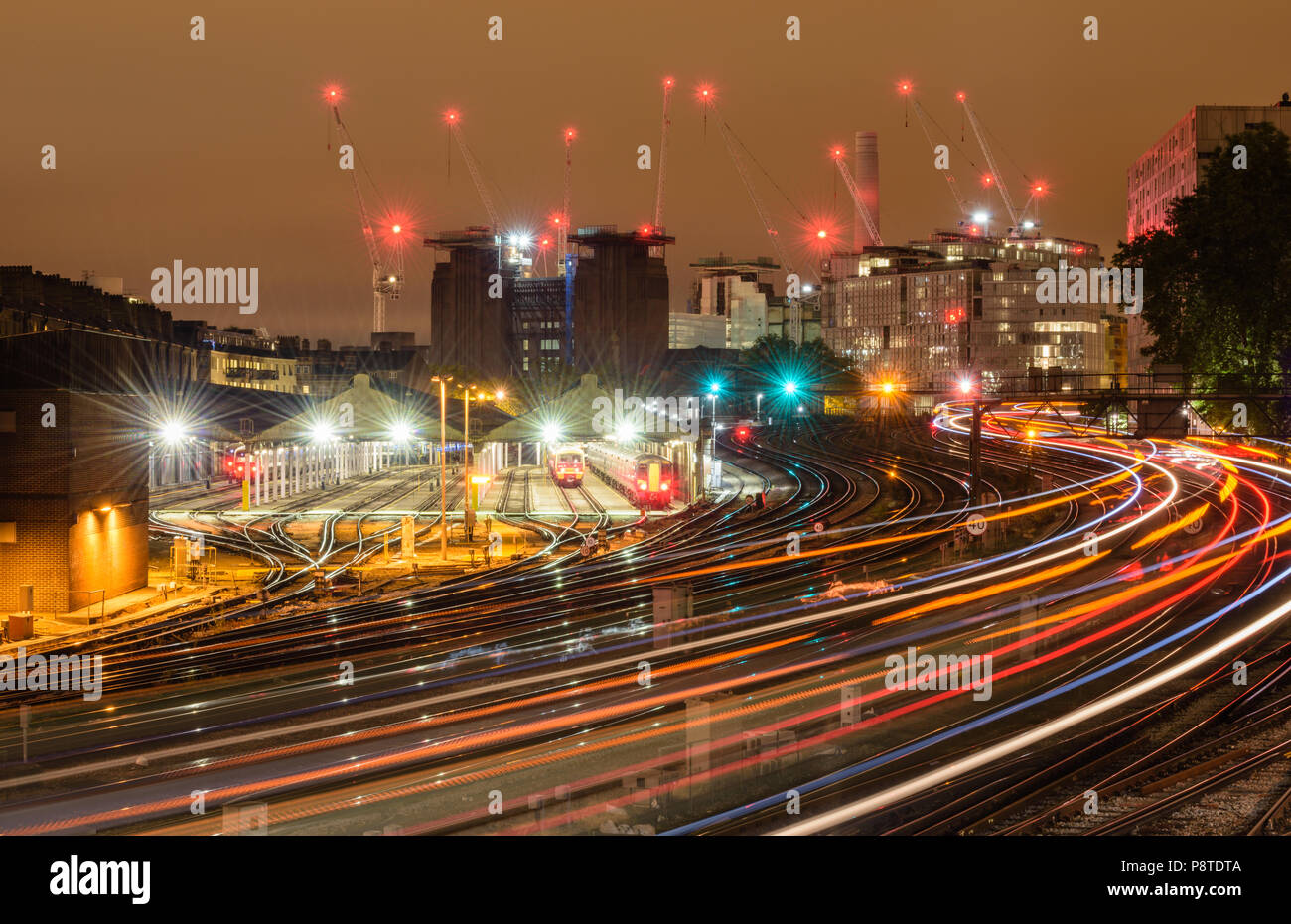 Nacht Blick von Ebury Bridge in Richtung dekonstruiert Battersea Power Station, London, mit leichten Wanderwegen der Züge nach und von der Victoria Station Stockfoto