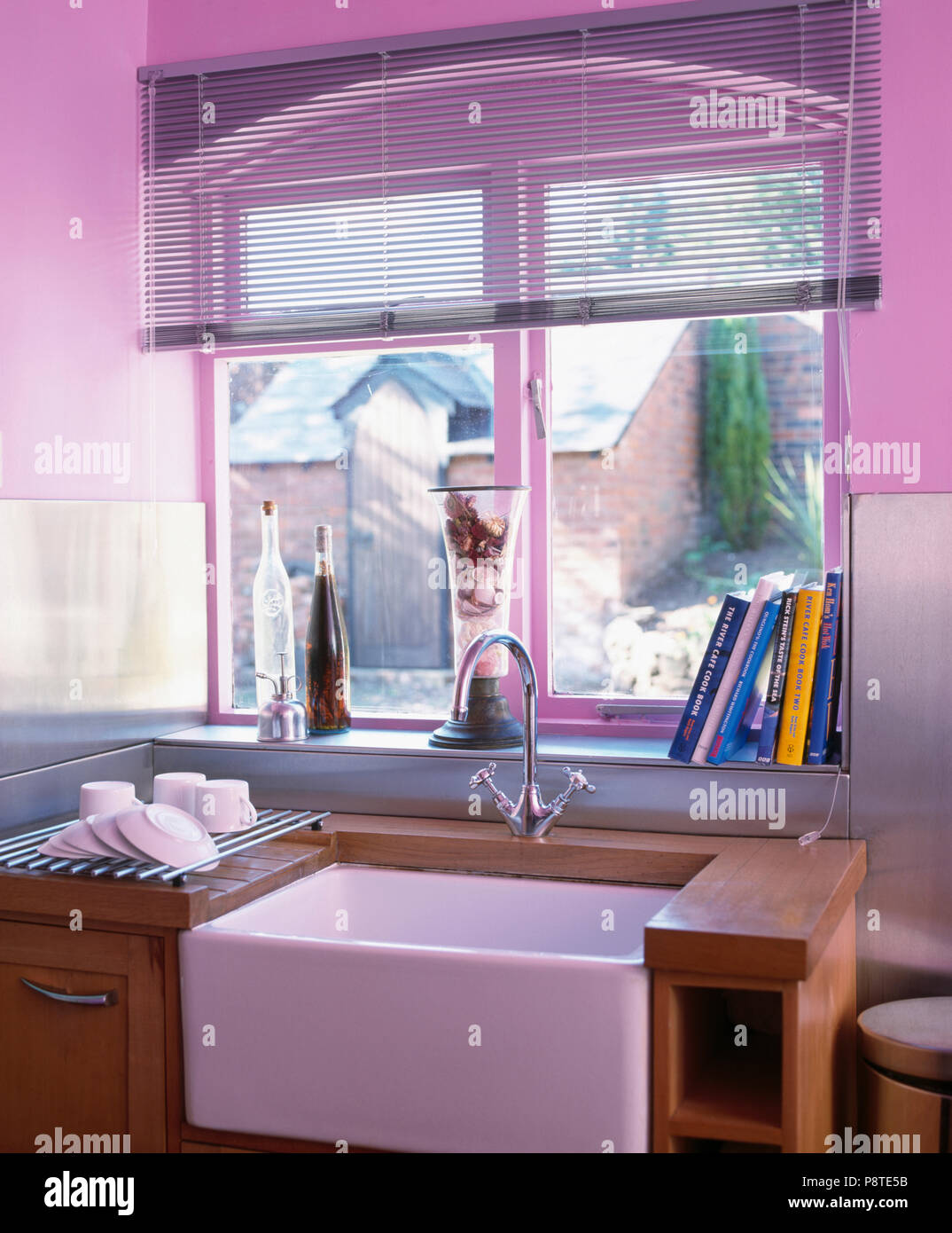 Blind Lattenrost auf Fenster über Belfast Waschbecken in der modernen mauve Küche Stockfoto