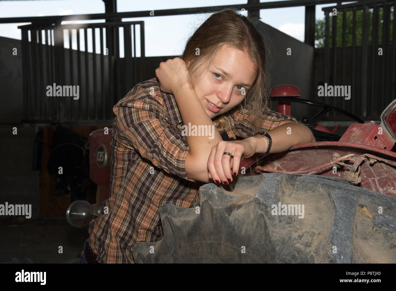 Blonde Dame am Traktor Stockfoto