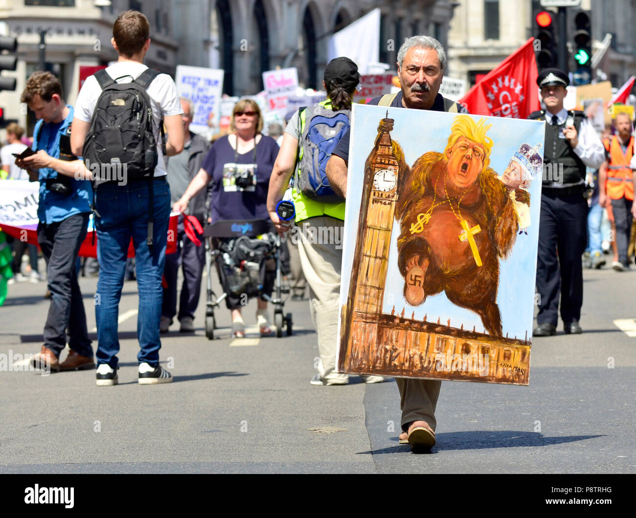 London, 13. Juli. Tausende von Portland Place, dem Parlament Platz gegen Präsident Donald Trump Besuch in Großbritannien zu protestieren. Politische Karikaturist Kaya Mar an der Spitze der ersten März mit einem seiner Werke Credit: PjrFoto/Alamy leben Nachrichten Stockfoto