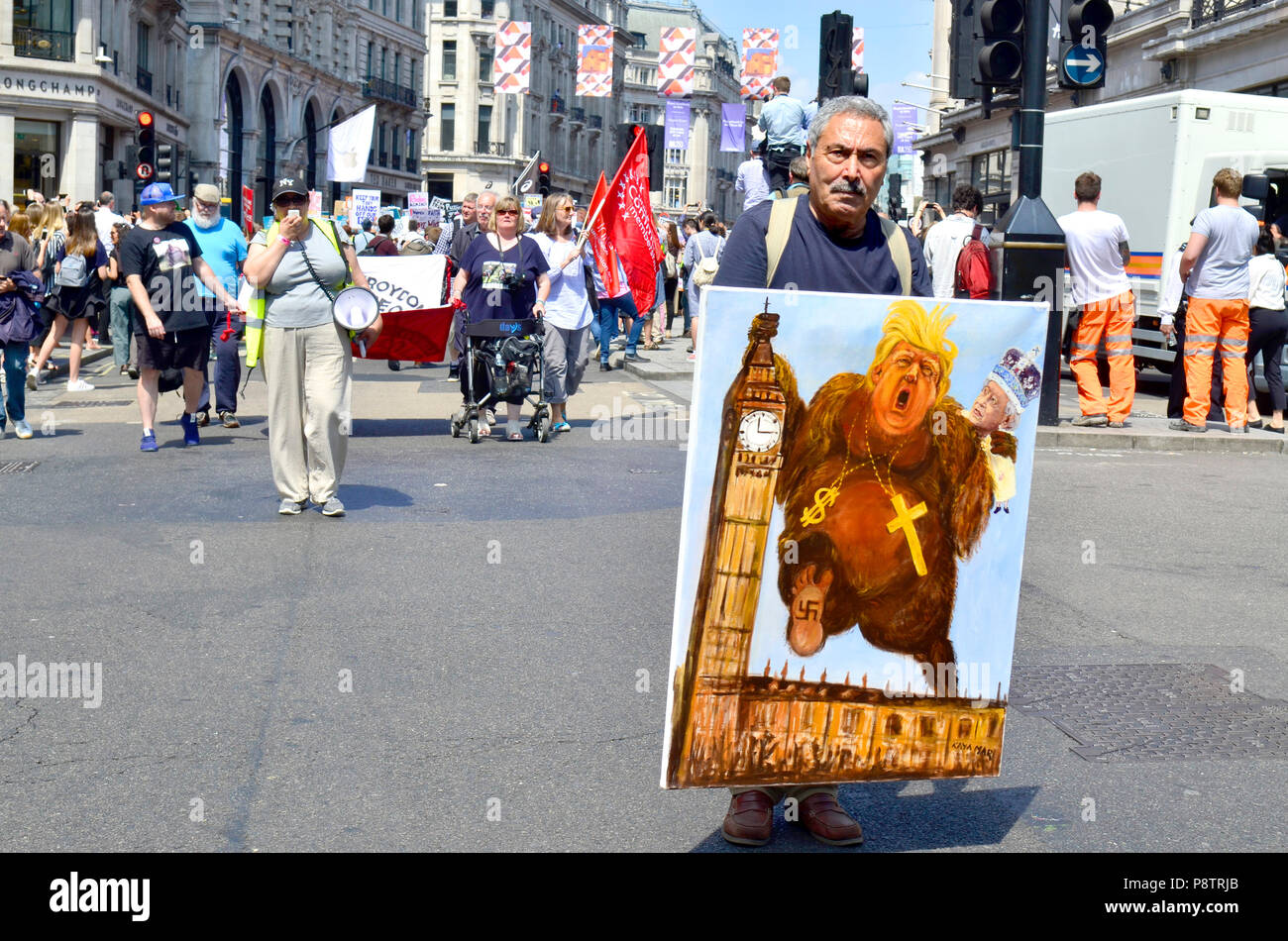 London, 13. Juli. Tausende von Portland Place, dem Parlament Platz gegen Präsident Donald Trump Besuch in Großbritannien zu protestieren. Politische Karikaturist Kaya Mar an der Spitze der ersten März mit einem seiner Werke Credit: PjrFoto/Alamy leben Nachrichten Stockfoto