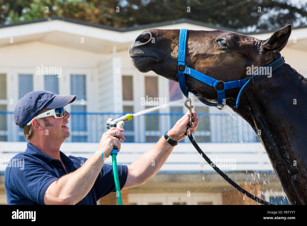 Sandbänke, Poole, Dorset, Großbritannien, 13. Juli 2018. Die britische Beach Polo Meisterschaften erhält unterwegs bei Sandbanks Beach, Poole an einem warmen sonnigen Tag. Die zweitägige Veranstaltung findet am Freitag und Samstag die Besucher des Beach Head der Aktion zu sehen. Zeit zum Abkühlen! Credit: Carolyn Jenkins/Alamy leben Nachrichten Stockfoto