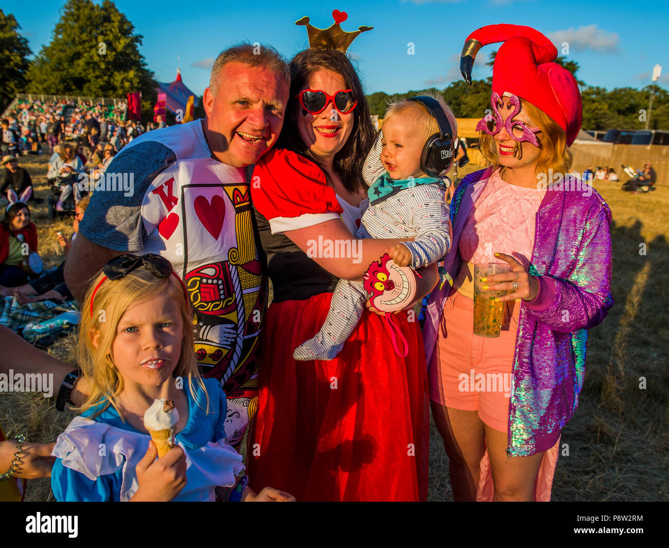 Henham Park, Suffolk, Großbritannien. 13. Juli 2018. Eine Familie kommen als Zeichen von Alice im Wunderland. Die Sonne beginnt mit dem ersten Tag zu - Die 2018 Latitude Festival, henham Park. Suffolk, 13. Juli 2018 Credit: Guy Bell/Alamy leben Nachrichten Stockfoto