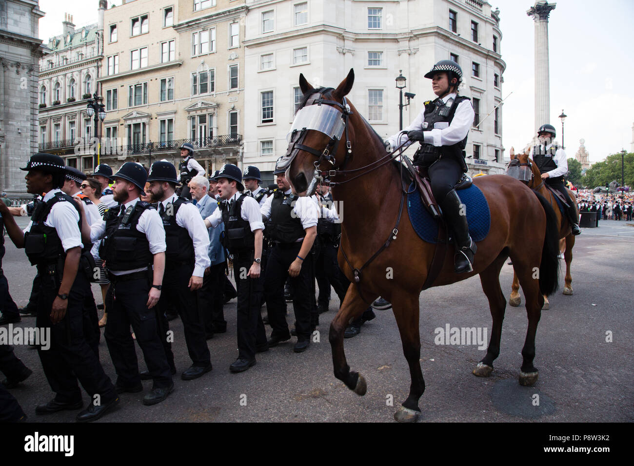 London UK, dem 13. Juli 2018 Der Führer Jeremy Corbyn wird von der Polizei nach dem Gespräch an der Demonstration gegen Präsident des Trump Besuch in Großbritannien auf dem Trafalgar Square begleitet. Credit: Thabo Jaiyesimi/Alamy leben Nachrichten Stockfoto