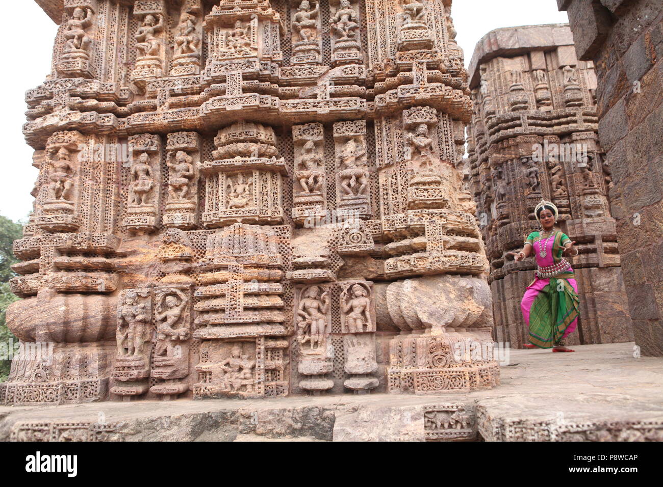 Odissi ist eines der acht klassischen Tanzformen Indiens, vom Zustand von odisha. Hier die Tänzerin stellt sich vor Tempeln mit Skulpturen Stockfoto