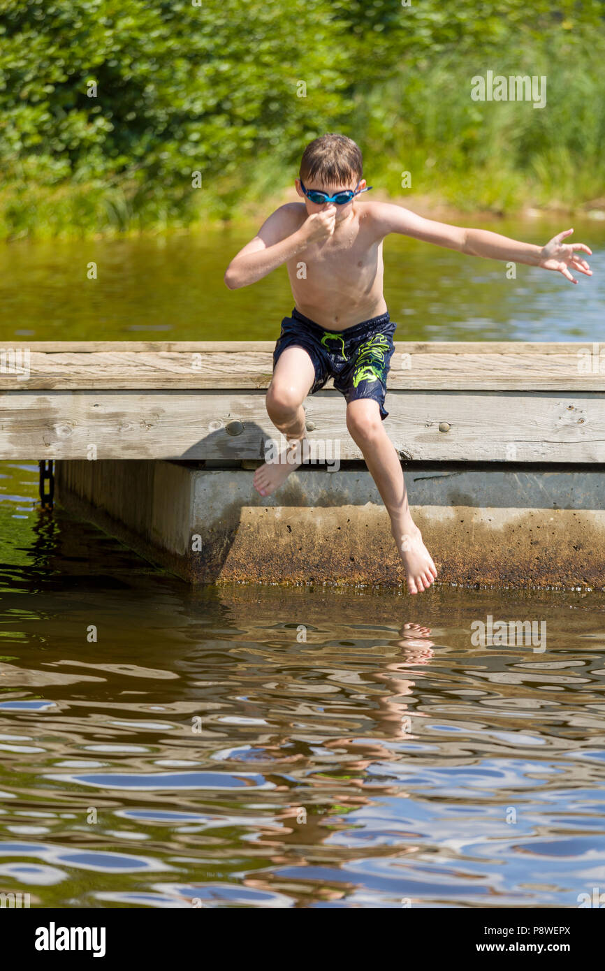 Junge in See Wasser Sprung vom Steg Stockfoto