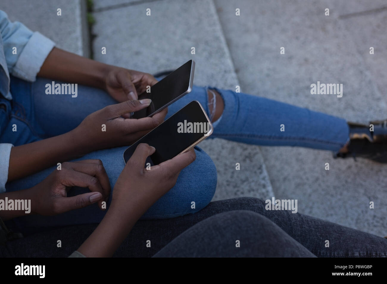 Zwillinge Geschwister mit Handy auf einem Schritte Stockfoto