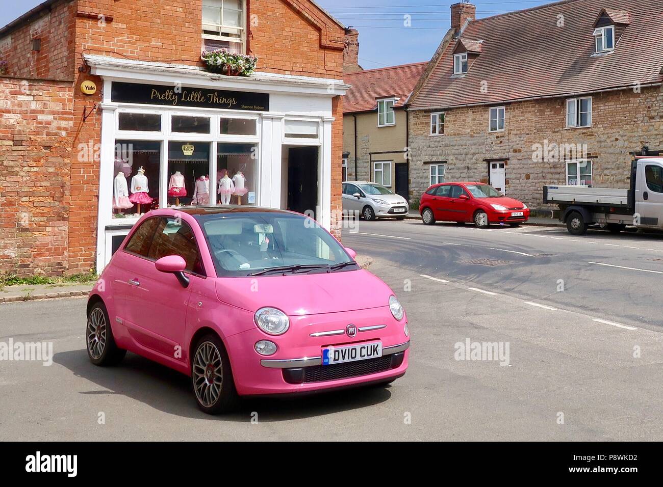 Leuchtend rosa Fiat 500 Vor dem hübschen kleinen Dinge shop in Kineton, Wark. Stockfoto
