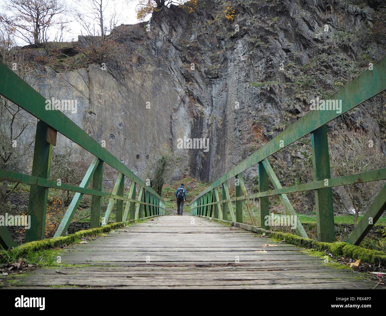 Mann auf der grünen Brücke vor einer großen Wand Stockfoto