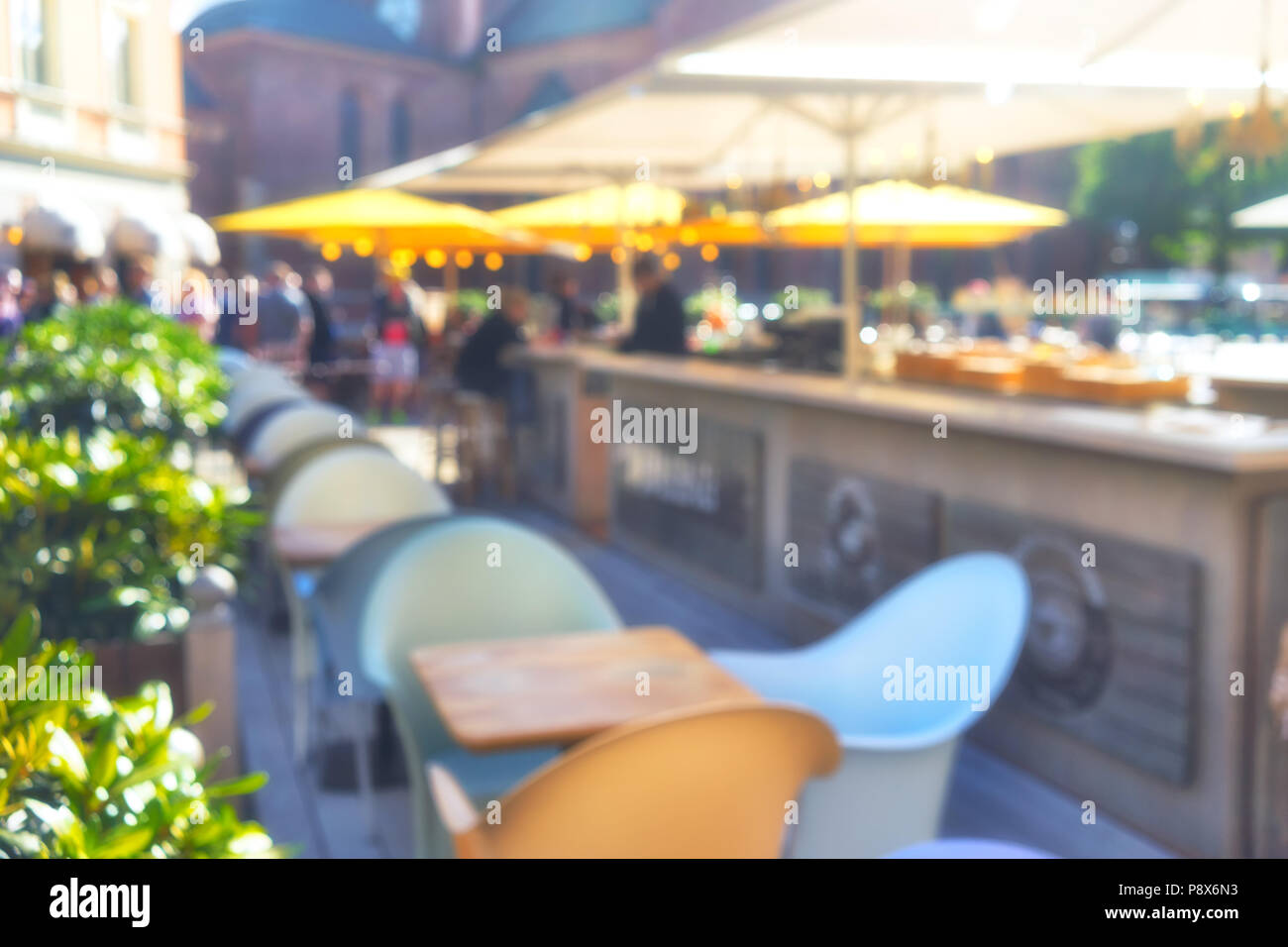 Sonnenschirme Cafés im Freien in der schönen Sonnenschein und Touristen im Dome Square in Riga. Verschwommen Stockfoto