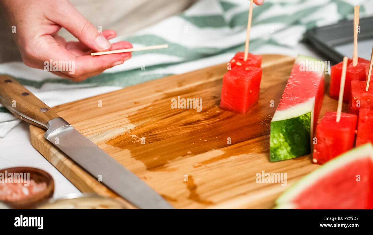 Wassermelone in Würfel schneiden für die Zubereitung von Schokolade Wassermelone beißt. Stockfoto