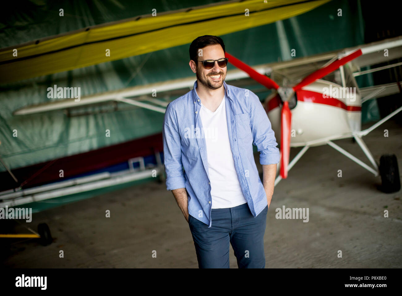 Hübscher junger Mann im Hangar Stockfoto