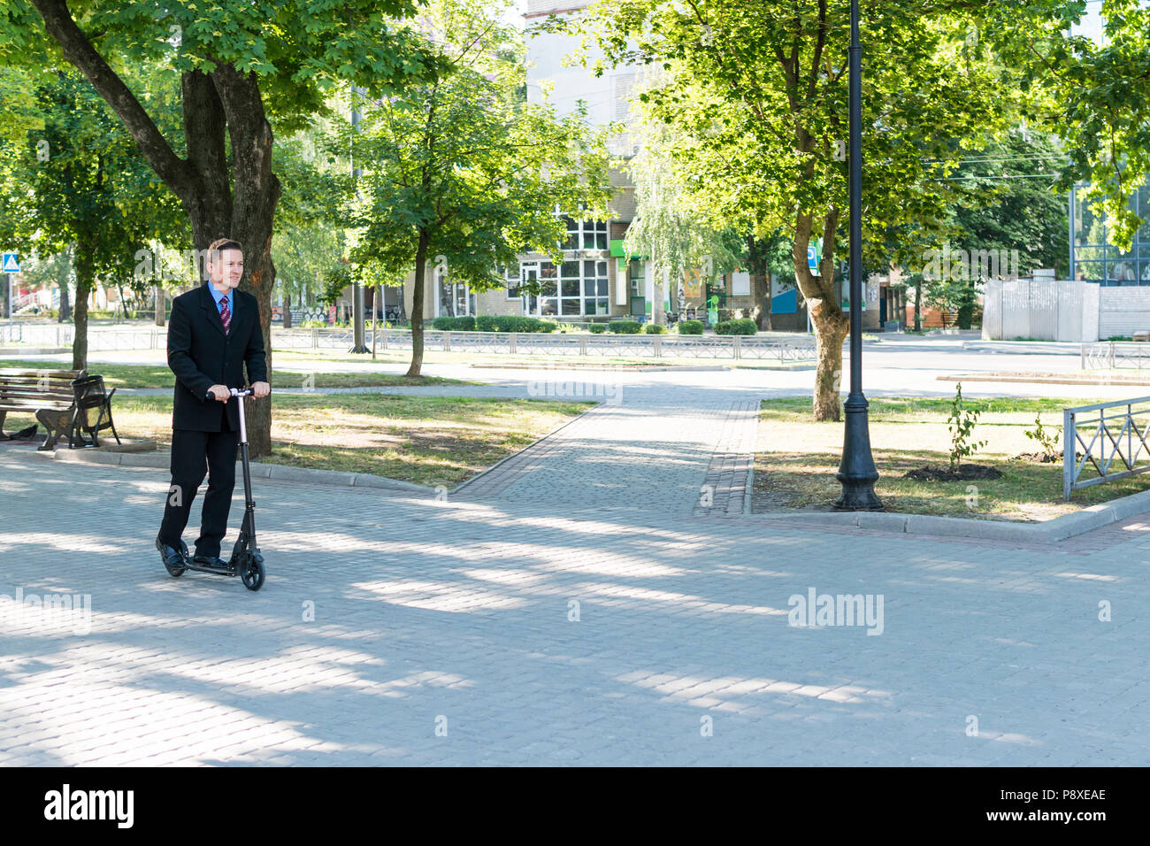 Unternehmer ist Reiten in Park auf Scooter Stockfoto