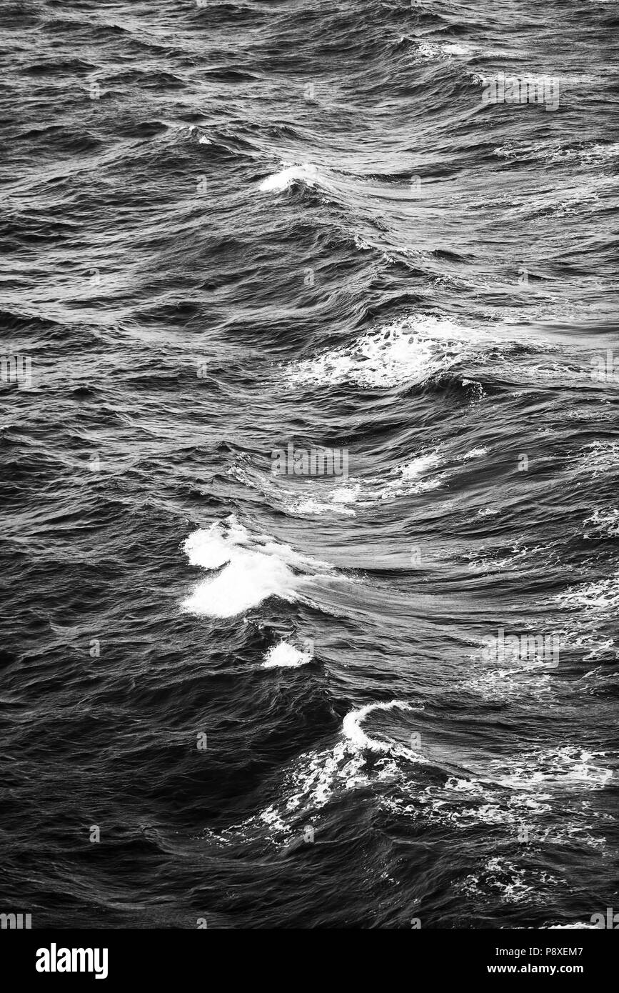 Ocean Waves mit kleinen weißen Kappen Hintergrund in Schwarz und Weiß Stockfoto