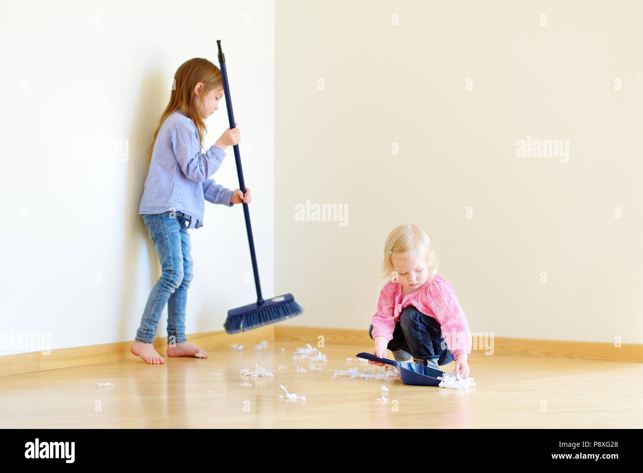 Zwei nette Mädchen zu helfen, ihre Mutter zu Hause zu reinigen Stockfoto