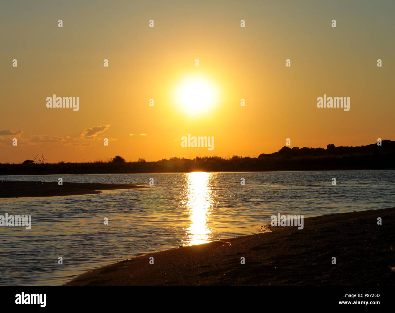 Reflektion des Sonnenlichts auf das fließende Wasser. Foto vor Sonnenuntergang am Strand in Gizzeria, Kalabrien, Italien. Stockfoto