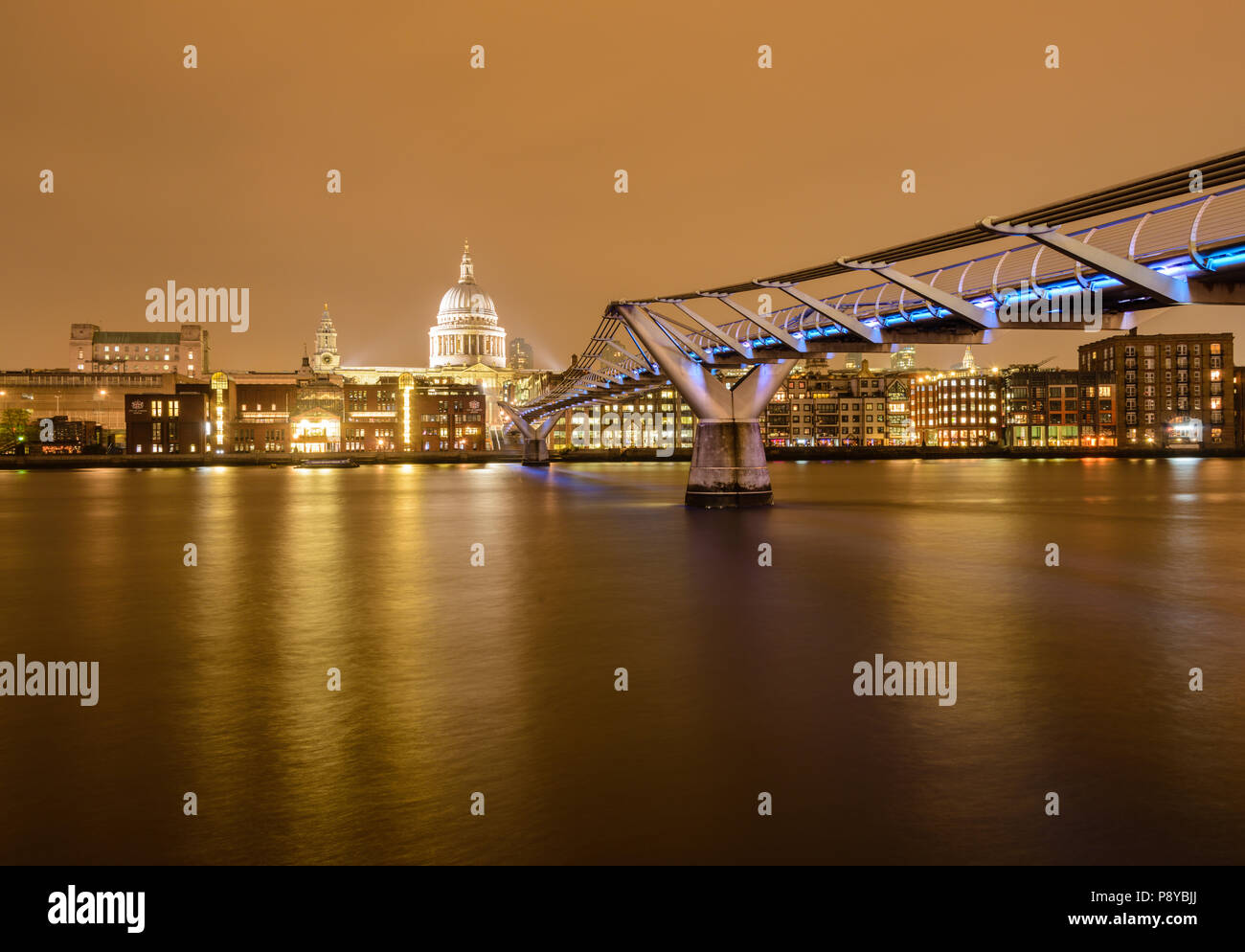 Lange Belichtung Landschaft Blick auf die St. Pauls Kathedrale und der Londoner Millennium Fußgängerbrücke in der Nacht mit Beleuchtung in der Themse wider Stockfoto
