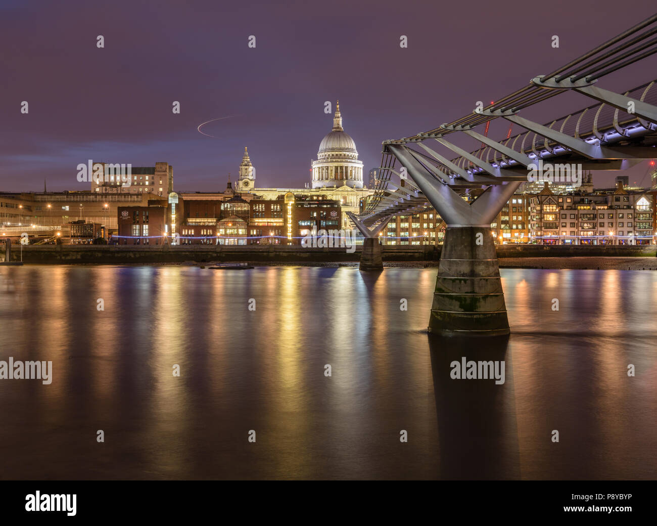 Lange Belichtung Landschaft Blick auf die St. Pauls Kathedrale und der Londoner Millennium Fußgängerbrücke in der Nacht mit Beleuchtung in der Themse wider Stockfoto
