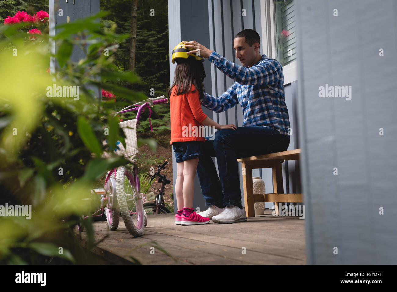 Vater helfen, seine Tochter mit dem Fahrrad Helm zu setzen Stockfoto