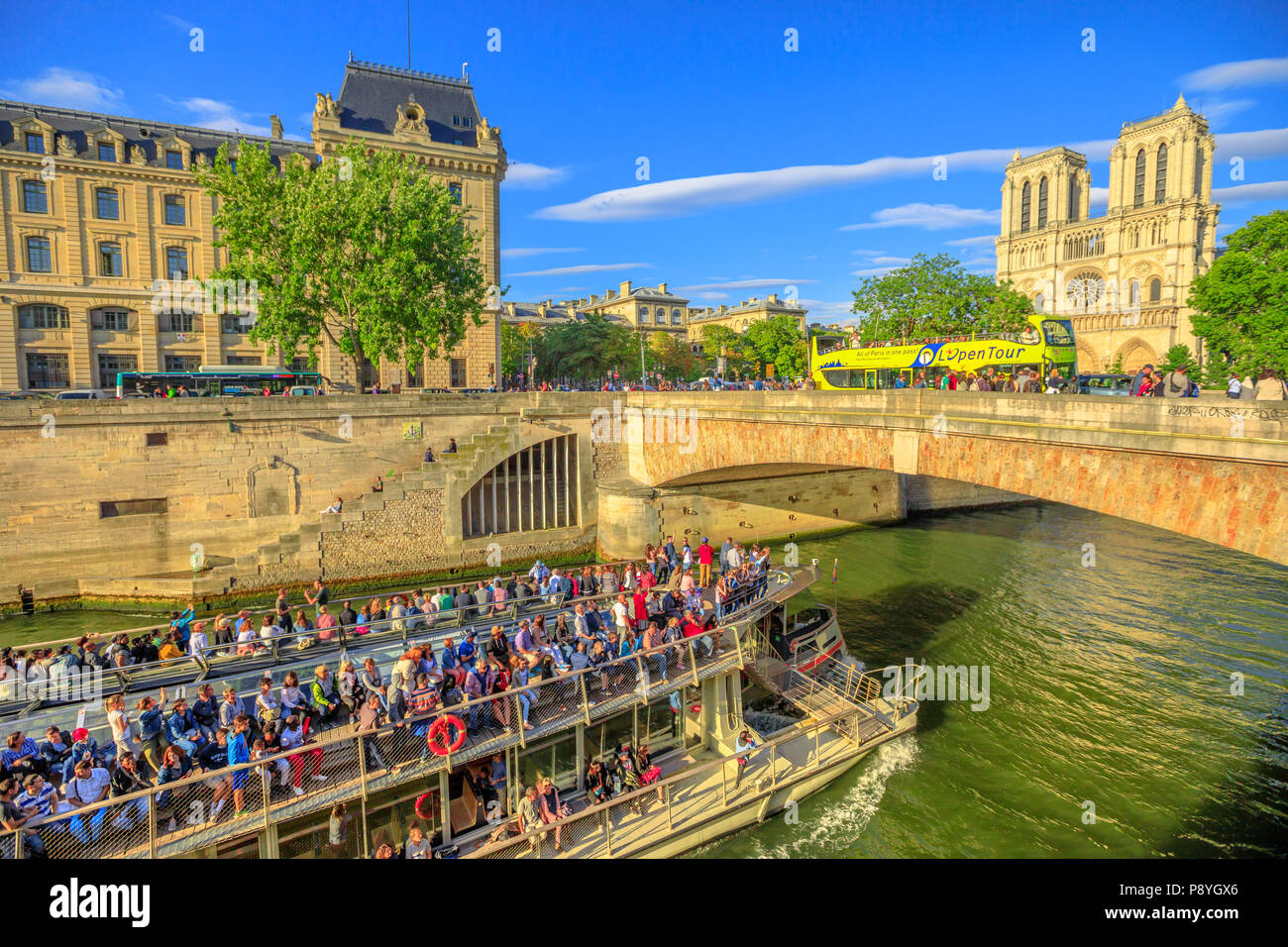 Paris, Frankreich, 1. Juli 2017: Bateaux-Mouches mit vielen touristischen während einer Reise auf dem Fluss Seine Pässe unter Pont Saint Michel. Kathedrale Unserer Lieben Frau und Conciergerie auf der Ile de la Cite. Stockfoto