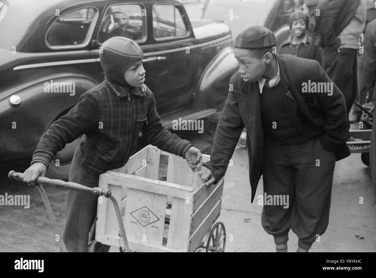 Zwei Jungen stehen vor der Grocery Store warten auf Aufträge in den Warenkorb Home Lebensmittel der Käufer, Südseite, Chicago, Illinois, USA, Russell Lee, Farm Security Administration, April 1941 Stockfoto