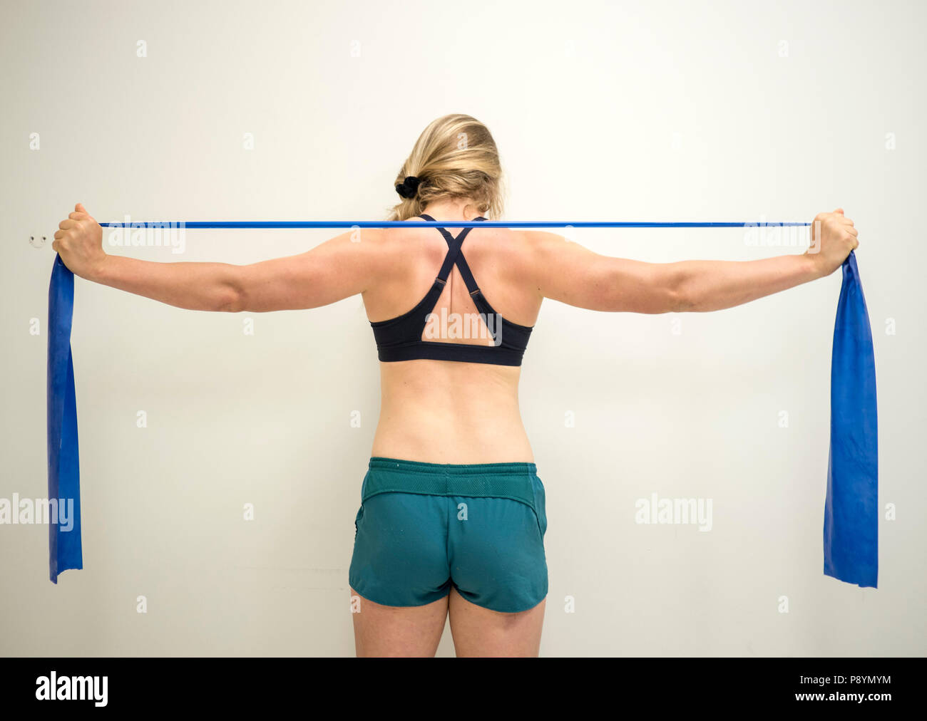 Starken weiblichen Athleten mit einem Widerstand theraband ihre Arme  Muskeln zu stärken Stockfotografie - Alamy