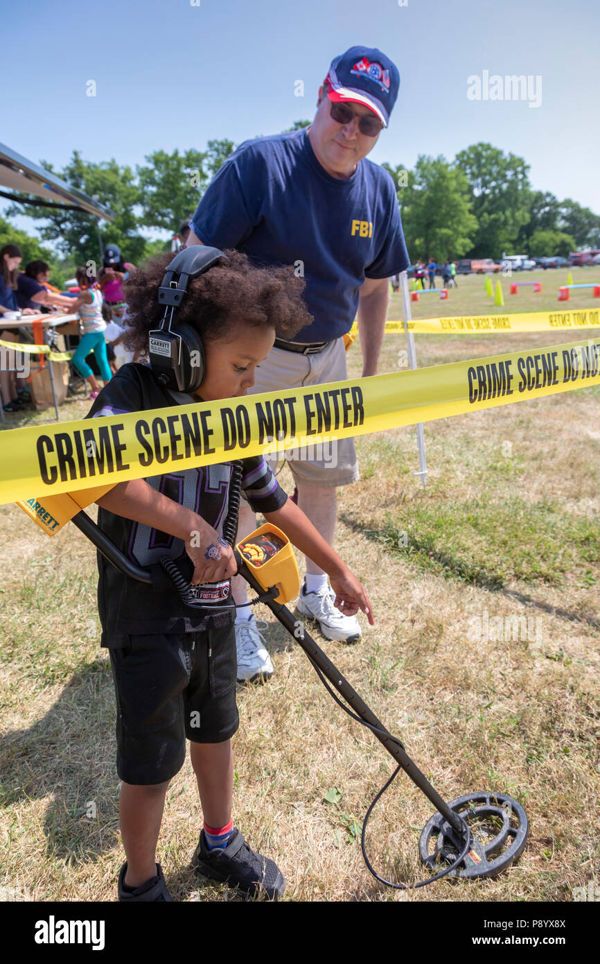 Detroit, Michigan - FBI-Agenten zeigten Kinder wie die Erkennung von Metall Ausrüstung zu verwenden, setzt das FBI an Tatorten. Kinder gesucht für Münzen Stockfoto
