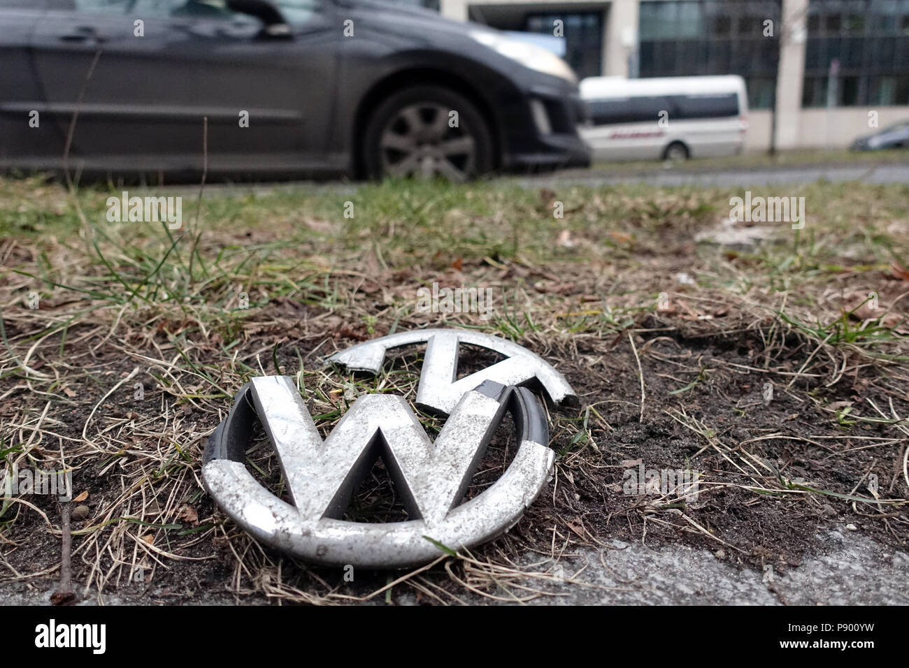 Berlin, Deutschland, gebrochene Grill Kühlergrill Emblem eines Volkswagen liegt auf der grüne Streifen von eine straße Stockfoto