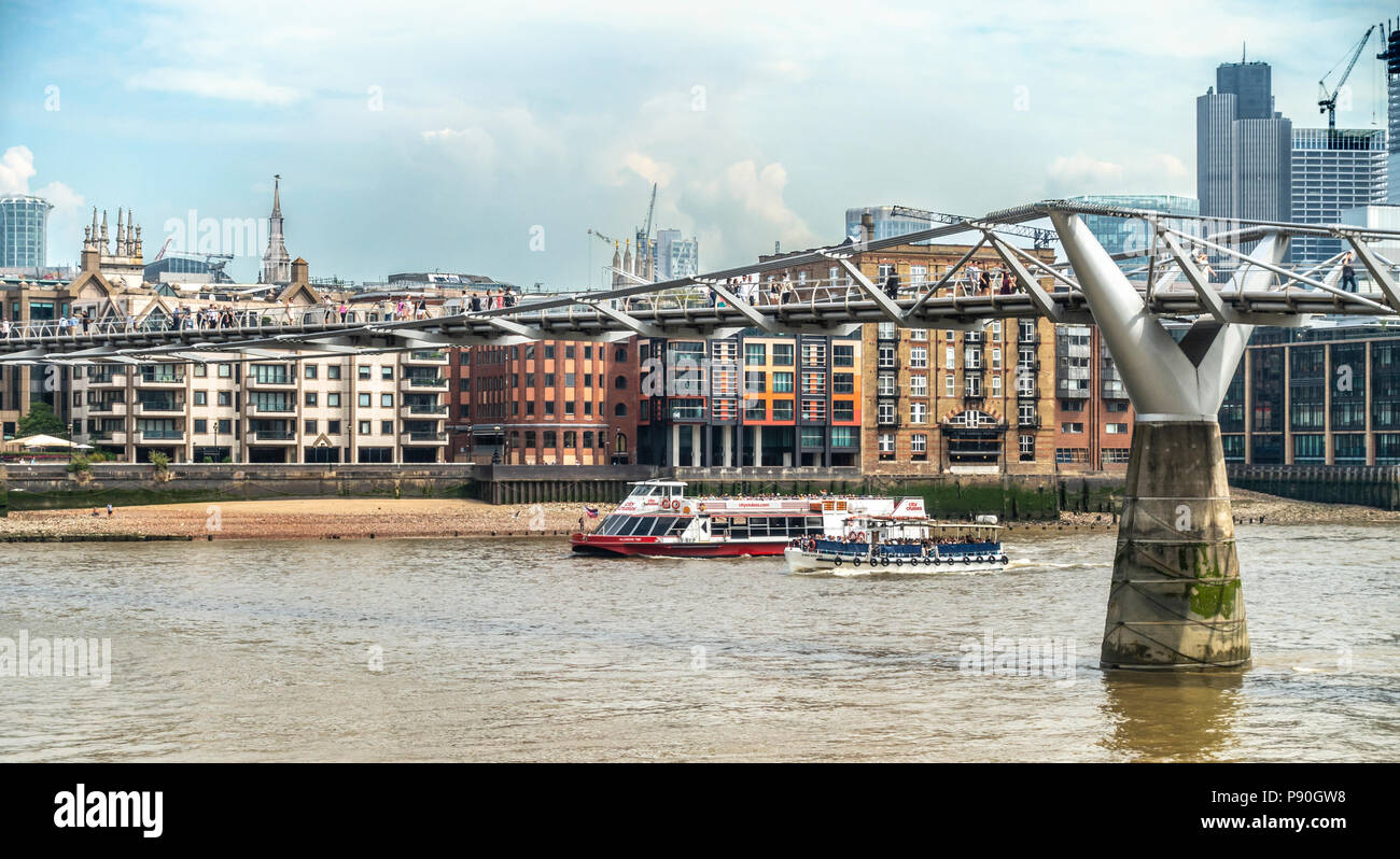 Fußgänger die Millenium Bridge fka Wackelbrücke, zwei Sightseeing Boote Sarah Kathleen & Millenium Zeit unterqueren mit Passagieren überschreiten. Stockfoto