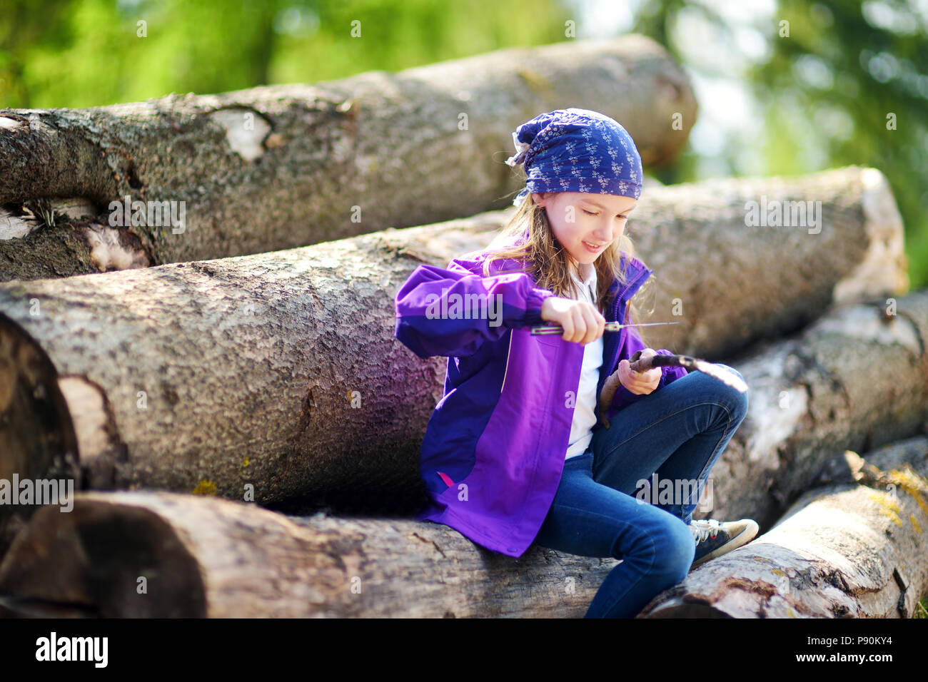 Süße kleine Mädchen sitzen auf Baum Archive mit einem Taschenmesser eine  wandern Stick zu reduzieren. Kind mit einem schnitzmesser Stockfotografie -  Alamy