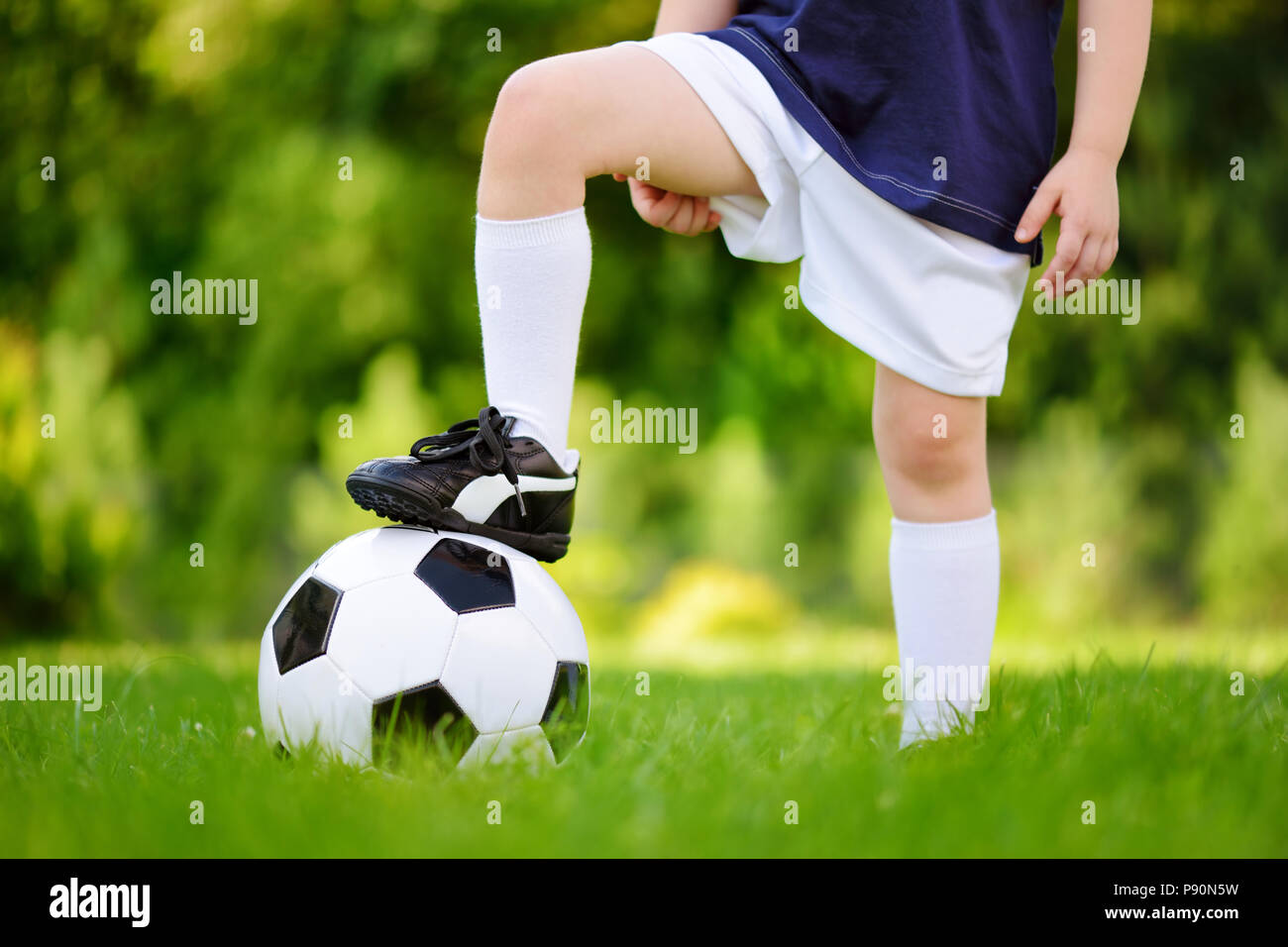 Nahaufnahme eines Kindes Spaß spielen ein Fußball-Spiel auf sonnigen Sommertag. Sport für Kinder. Kinder im Sport uniform. Stockfoto