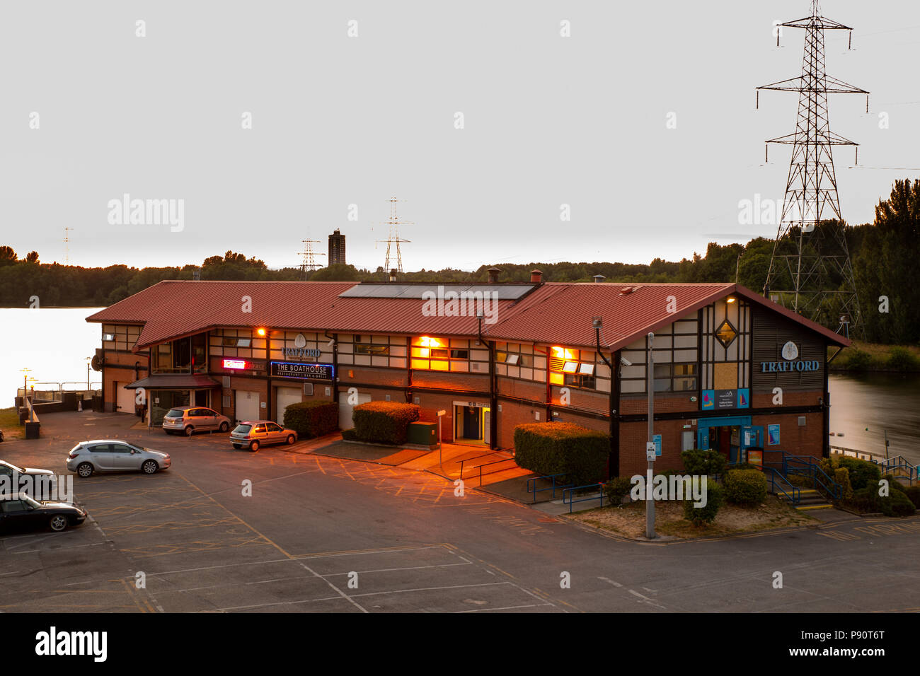Die Boathouse Restaurant Bar & Grill, Verkauf Water Park, Trafford, Greater Manchester, England, UK. Bei Sonnenuntergang mit Blick auf den See genommen. Stockfoto