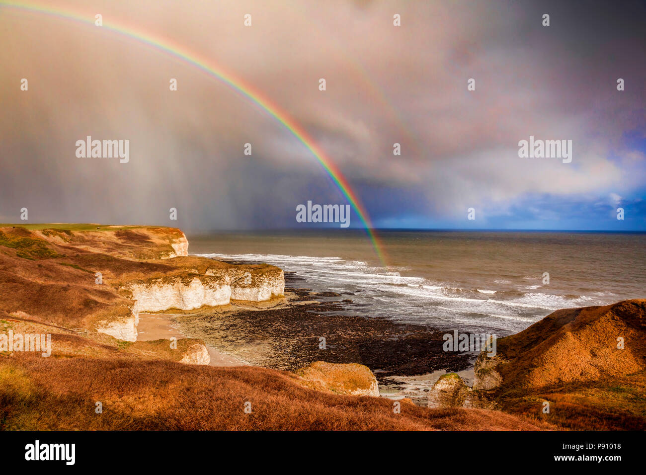 Wechselhaftes Wetter in den Kalkstein Felsen von Flamborough Head, East Yorkshire, England, UK, als ein sich näherndes Dusche Regen ein Regenbogen bringt. Stockfoto